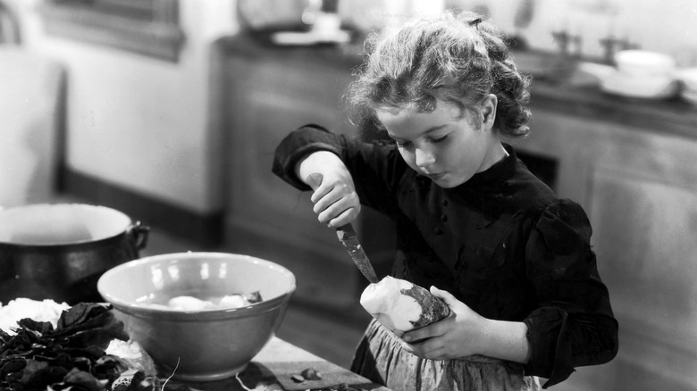 Shirley Temple cuts a potato