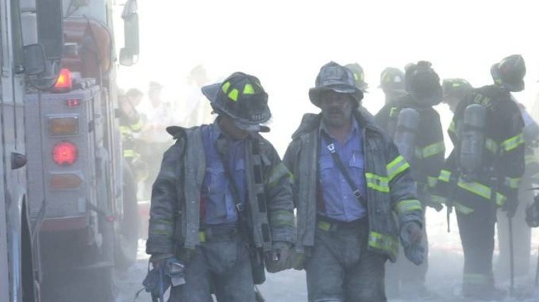 Firefighters walk through the rubble