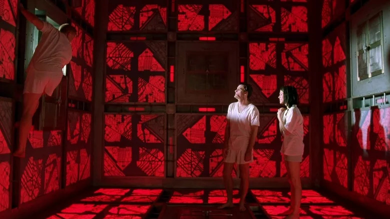 Three prisoners in neon red room