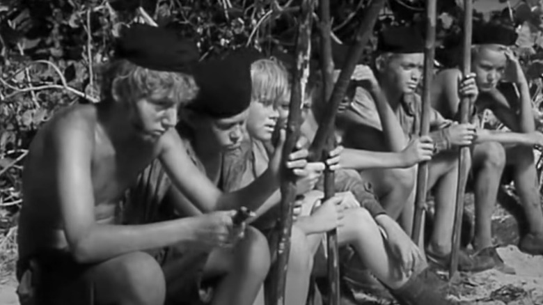 Boys seated on a log