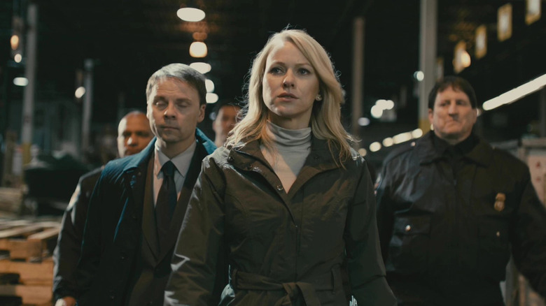 Naomi Watts flanked by law enforcement officers