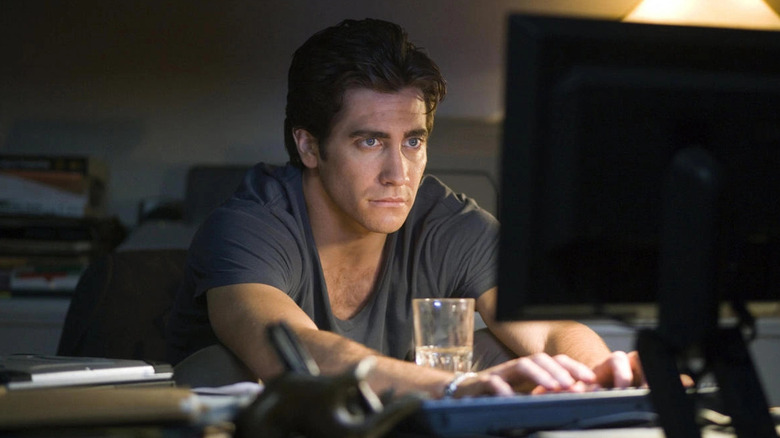 Jake Gyllenhaal sits at a computer