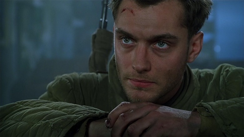 Jude Law as a soldier crosses his arms