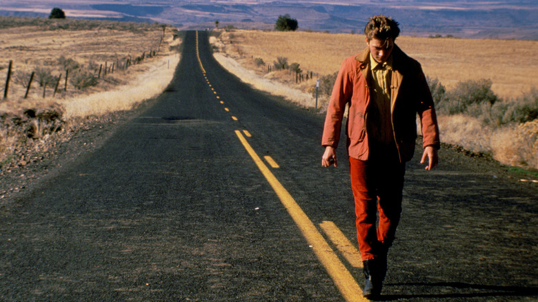 River Phoenix walking down an empty road