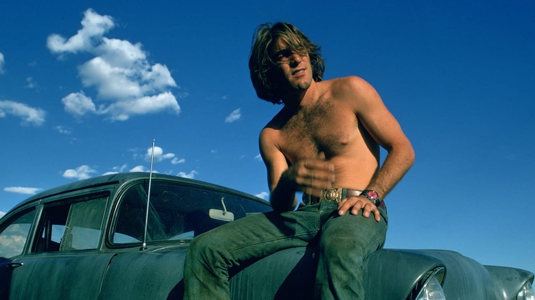 Dennis Wilson shirtless on a car