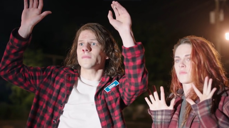 Jesse Eisenberg and Kristen Stewart with hands in air