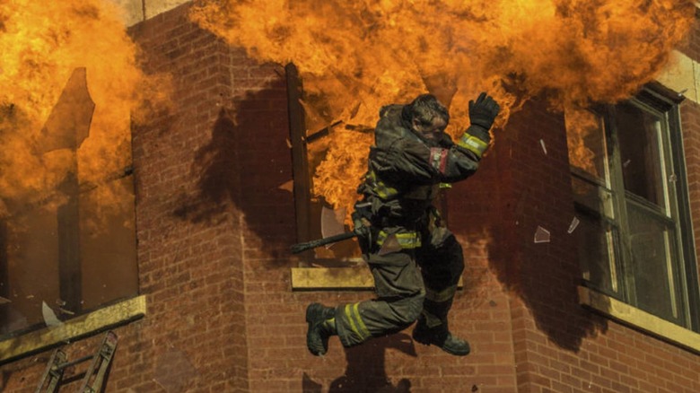 A firefighter jumps out a window