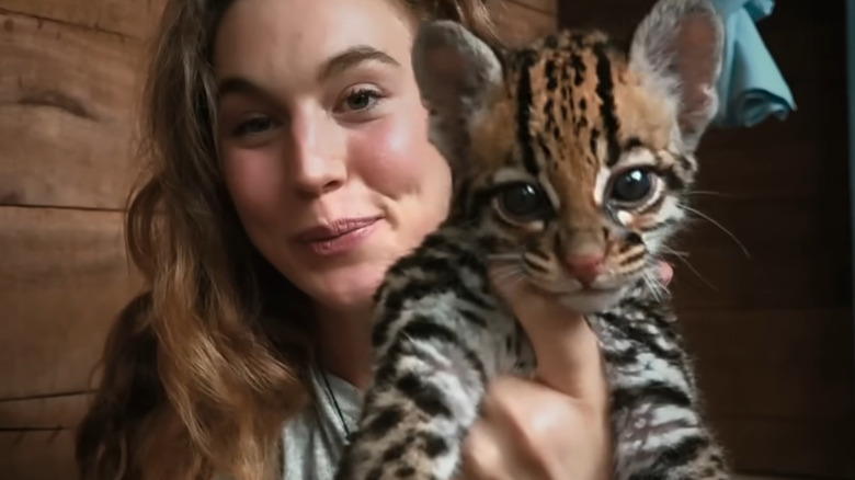 Woman holding baby ocelot