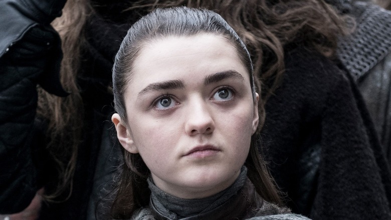 Arya standing in a crowd in Winterfell