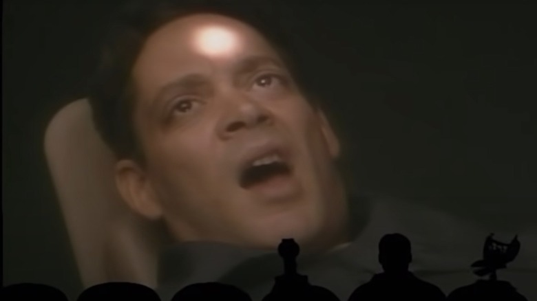 Raul Julia's face is frozen