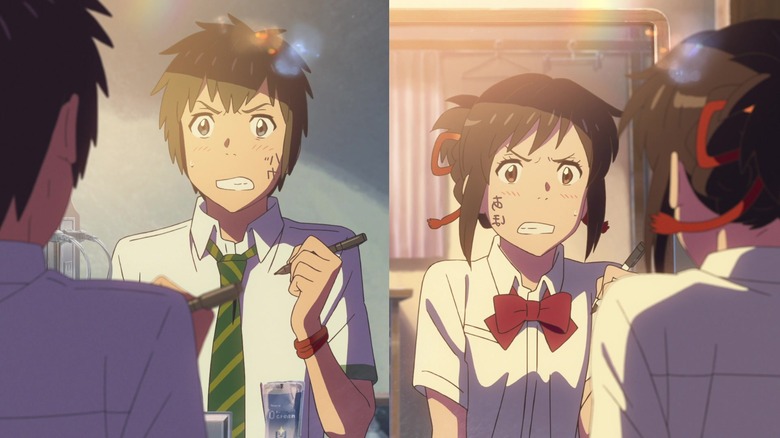 Taki and Mitsuha writing on faces