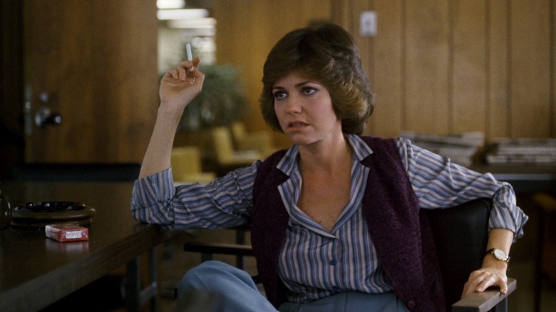 Sally Field sits at desk smoking