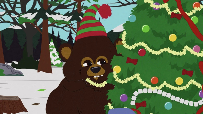 A bear next to a Christmas tree