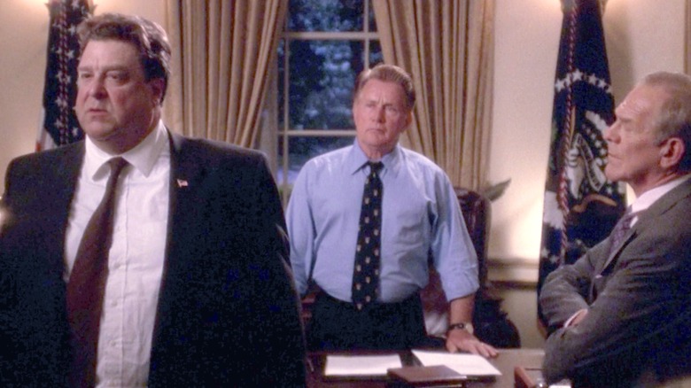 Bartlet standing behind his desk with Goodman and Leo in front