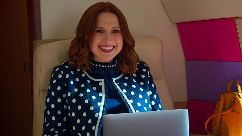 Kimmy Schmidt smiles broadly while using a laptop