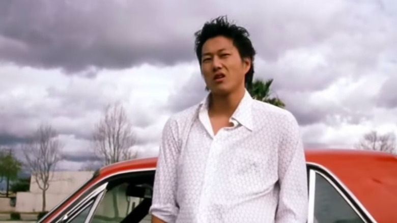 Han Lue leaning on car