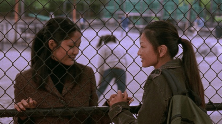 Wil and Vivian holding hands through fence