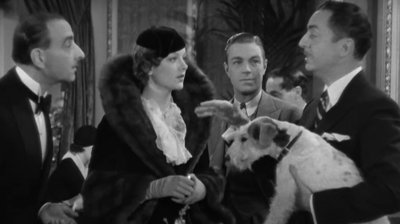 Nick Charles addresses Nora while holding their dog