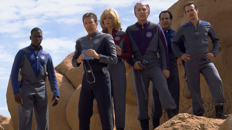 The cast of Galaxy Quest stand on rocks