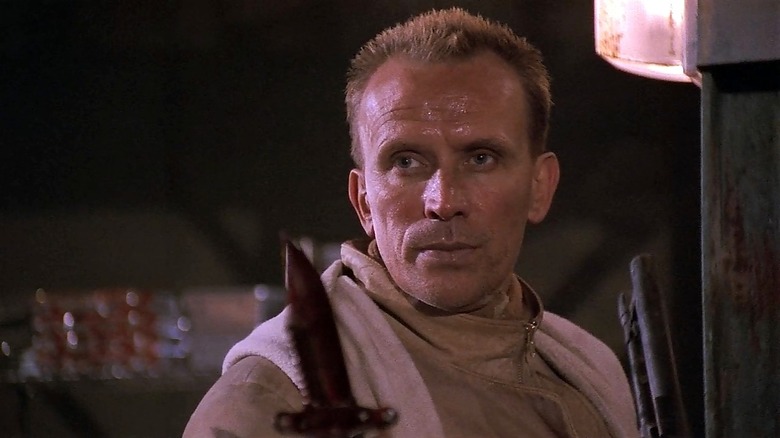 Peter Weller holds a knife