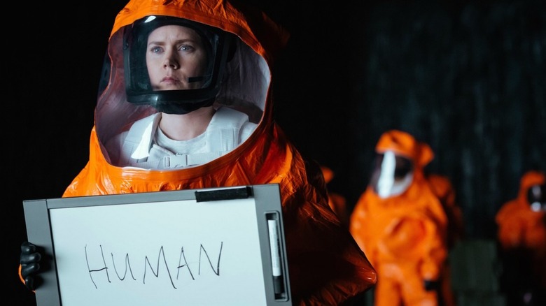 Amy Adams holding whiteboard up for aliens 