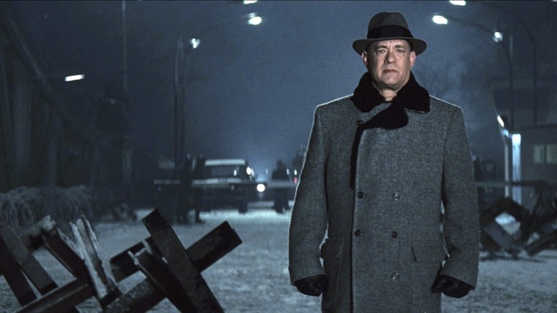 Hanks standing in coat and hat 