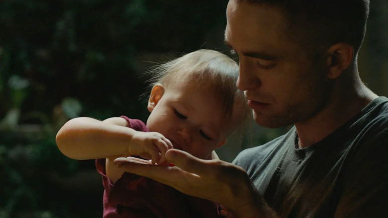 Robert Pattinson holds baby