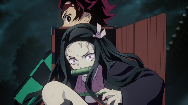 Nezuko grimacing on Tanjiro's back