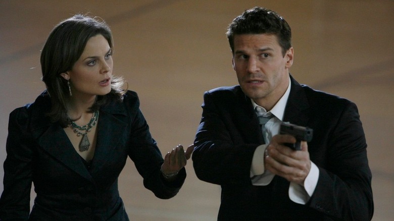 Booth aiming his gun near Bones