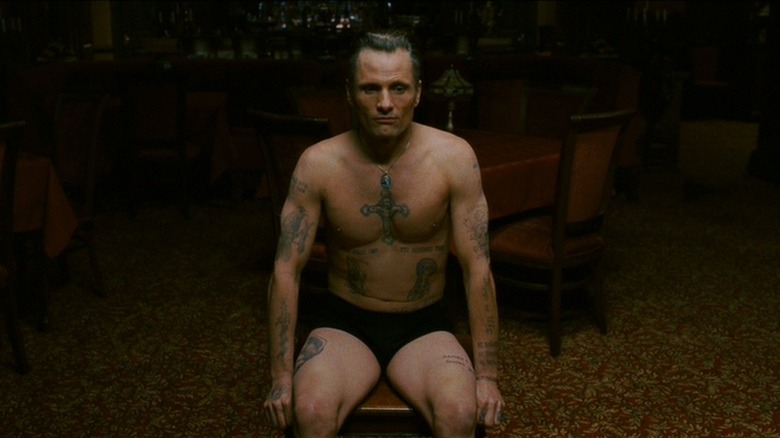 Shirtless Viggo Mortensen, seated