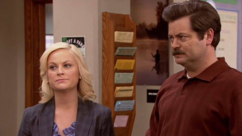 Amy Poehler and Nick Offerman stand