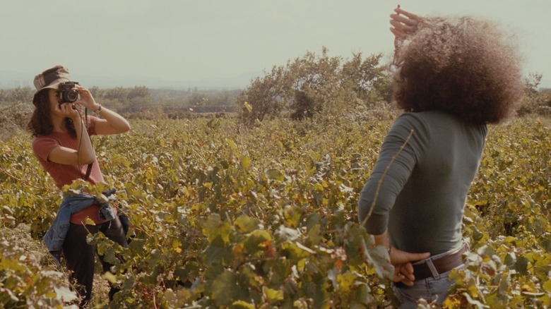 Woman photographs woman in field