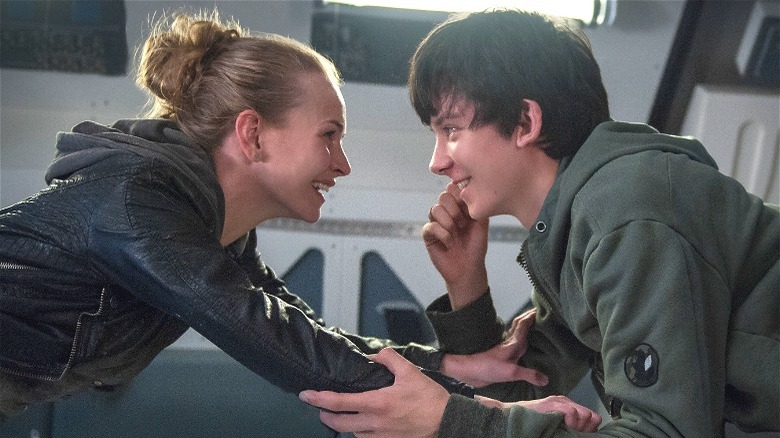 Asa Butterfield smiling at Britt Robertson