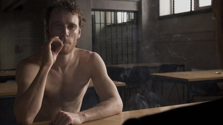 A shirtless Fassbender smoking