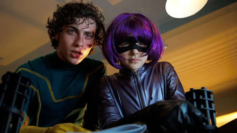 Kick-Ass and Hitgirl look out a window