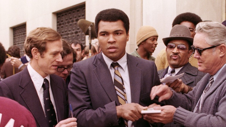 Muhammad Ali surrounded by people