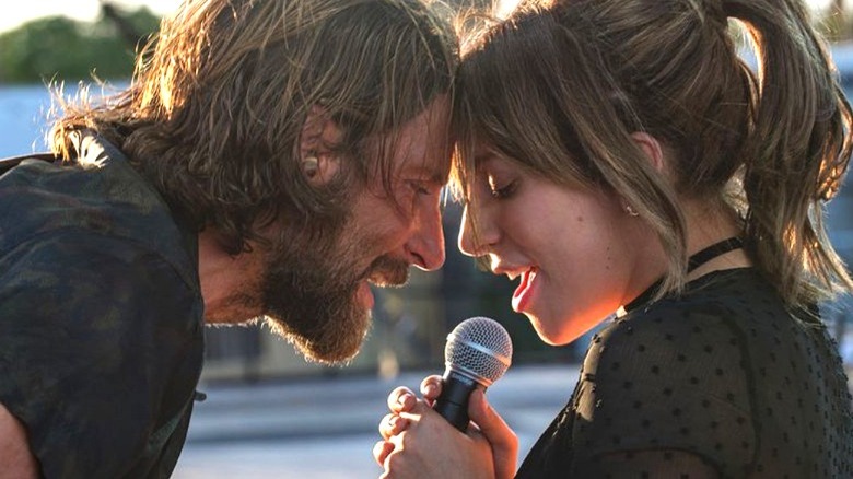 Jack and Ally singing into a microphone, foreheads together