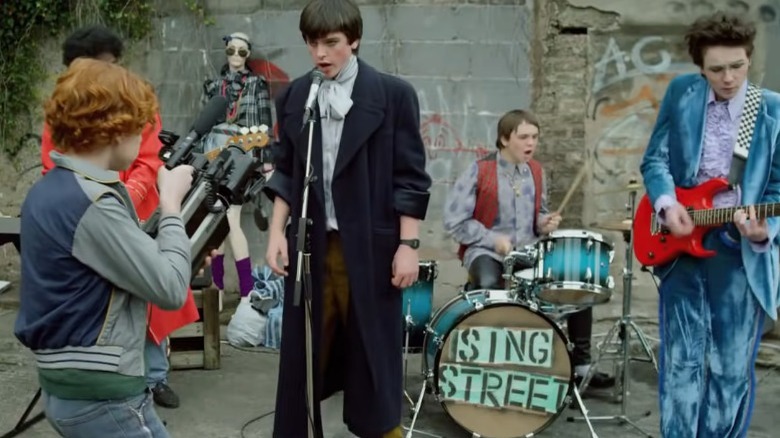 The band Sing Street performing in front of a dilapidated building