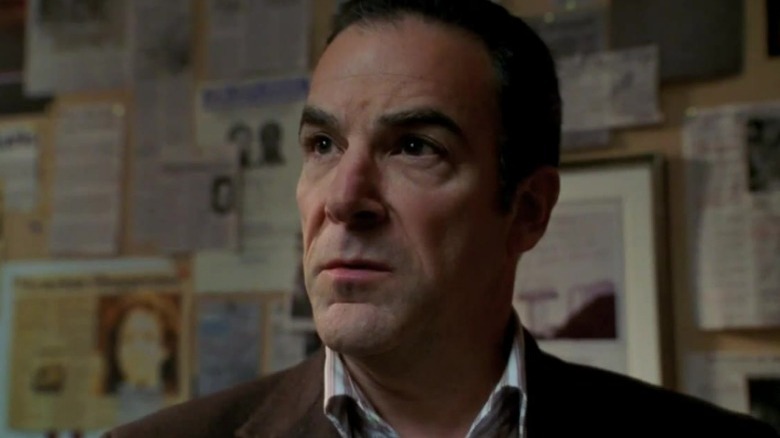 Jason Gideon next to crime board