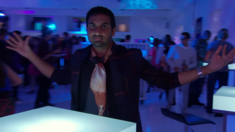 Tom Haverford gestures at the party behind him