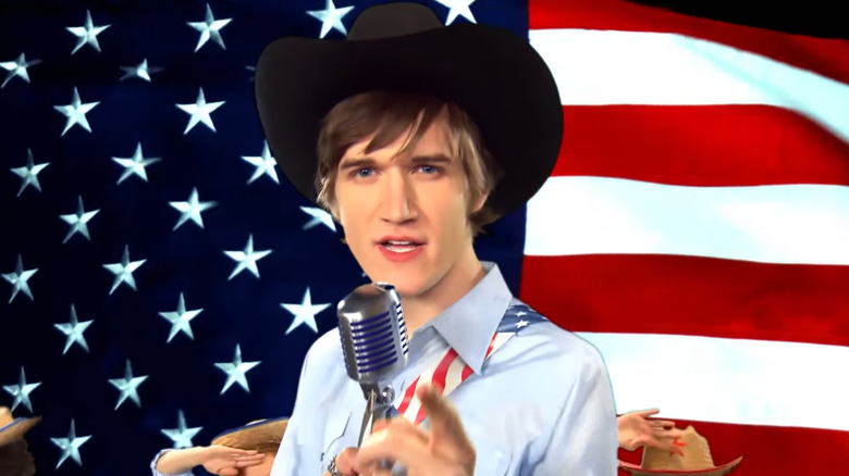 Bo Burnham stands in front of a US flag