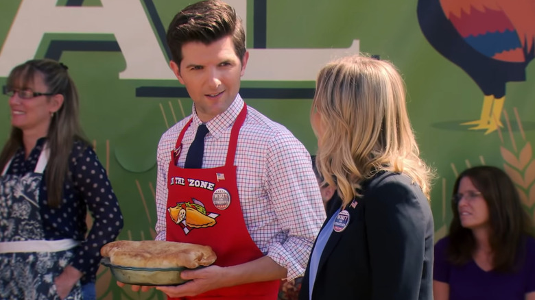 Ben Wyatt holds a pie while talking to Leslie Knope
