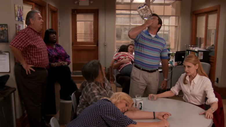 Ron Swanson chugs alcohol as everyone watches