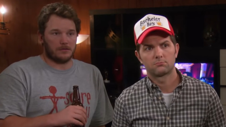 Chris Pratt holds a beer and Adam Scott wears a baseball cap