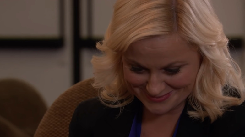 Leslie Knope looks down smiling