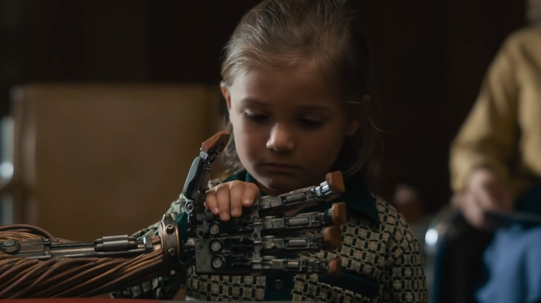 Little girl holds robot's hand