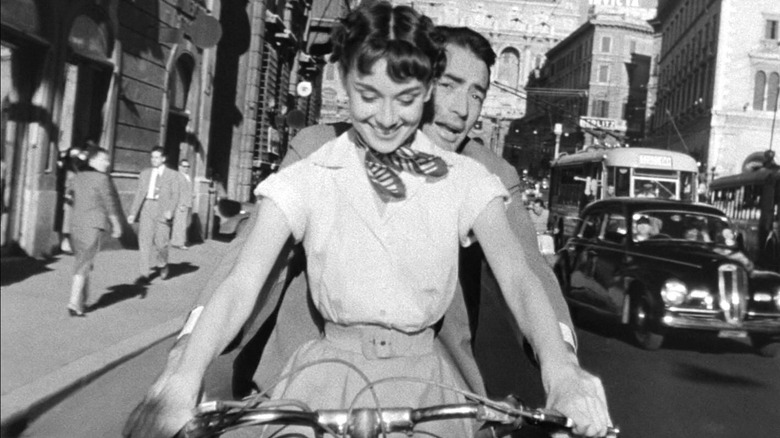 Audrey Hepburn and Gregory Peck riding a Vespa