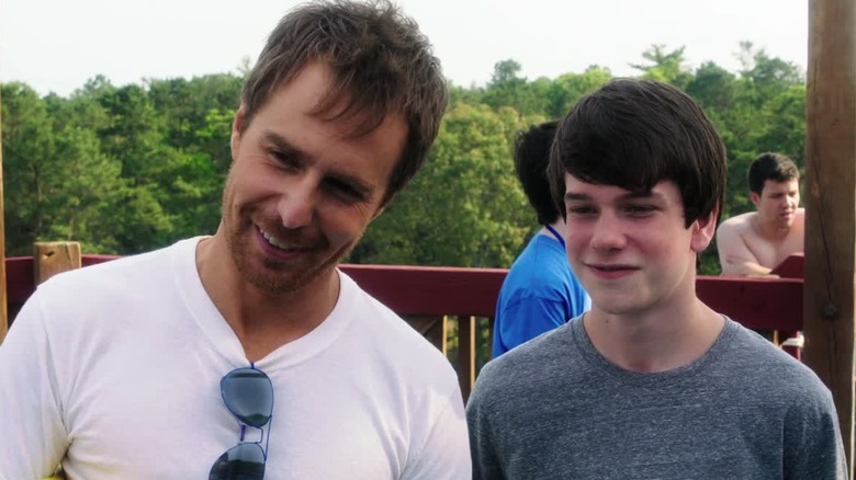 Liam James and Sam Rockwell, both smiling