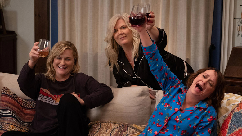 Characters giving a toast with wine on the couch