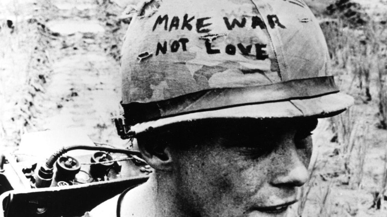 American soldier with customized helmet walking through jungle